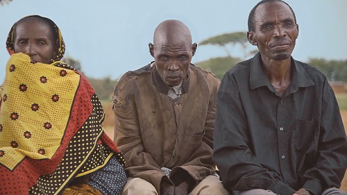 Matias, center, sits with his brother and sister-in-law at an eye care camp in Tanzania held by Moran’s Global Outreach Division.