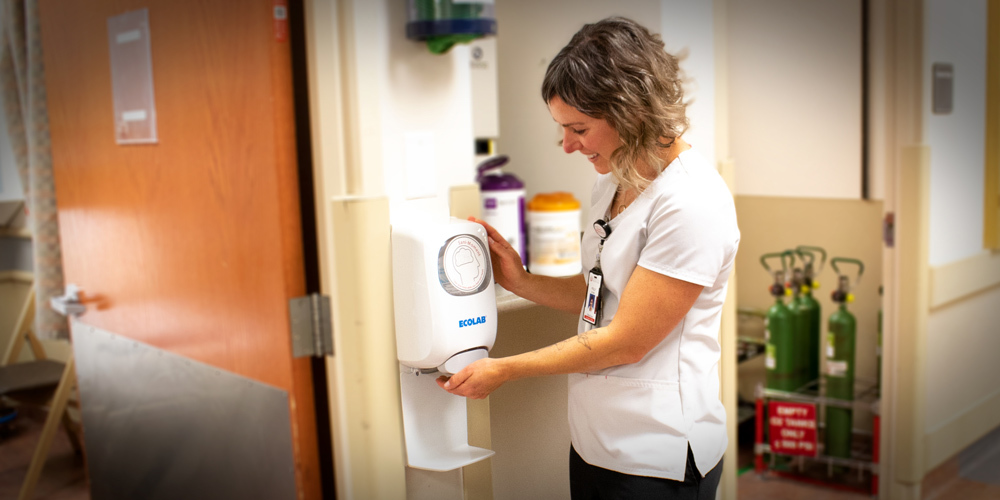 A health care worker sanitizing her hands